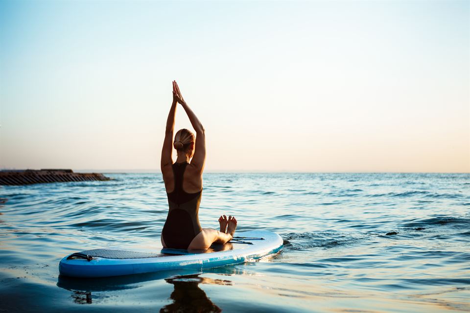 vipvipvillas-actividades-paddle-sup-yoga- (4) postura de yoga en tabla de paddle surf